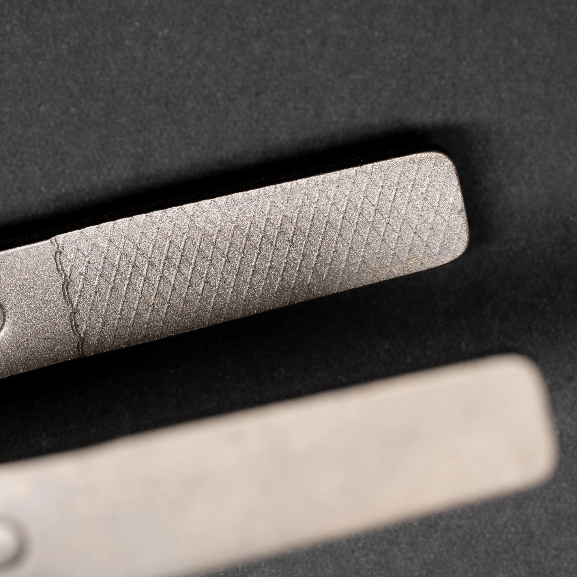 TriCamp Titanium Tongs in use — gripping food over campfire, lightweight camp kitchen tool